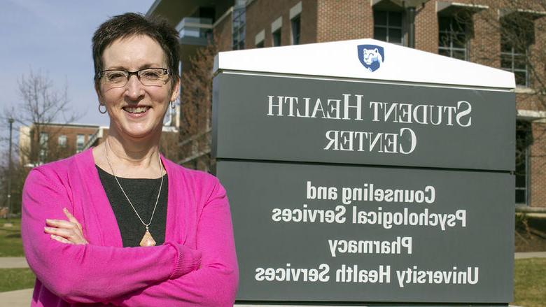 Shelley Haffner stands in front of a sign that reads "Student Health Center" in 2015